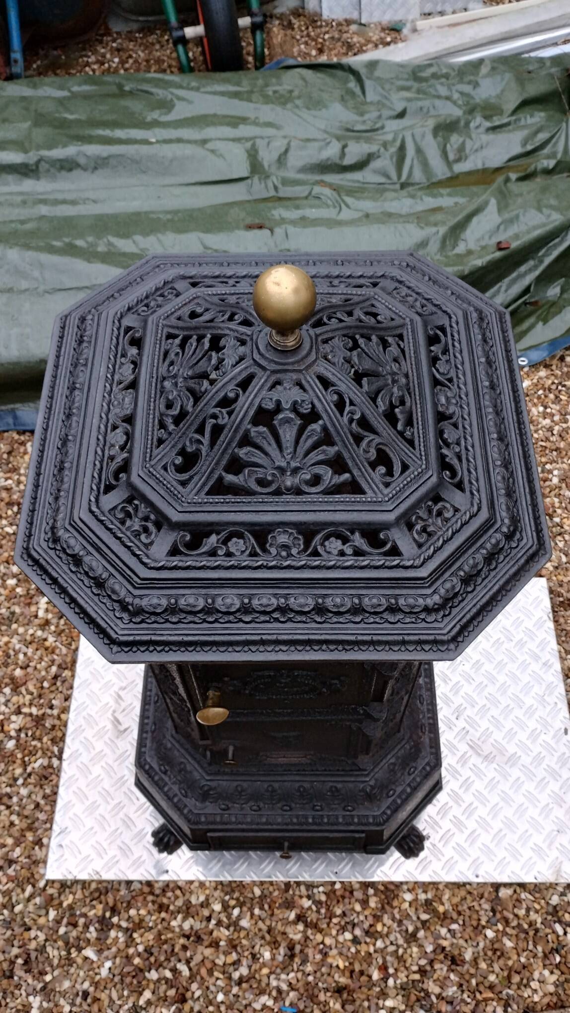 Black cast iron wood burning stove with solid brass handle.