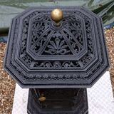 Black cast iron wood burning stove with solid brass handle.