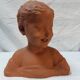 Terracotta bust of a smiling little boy.