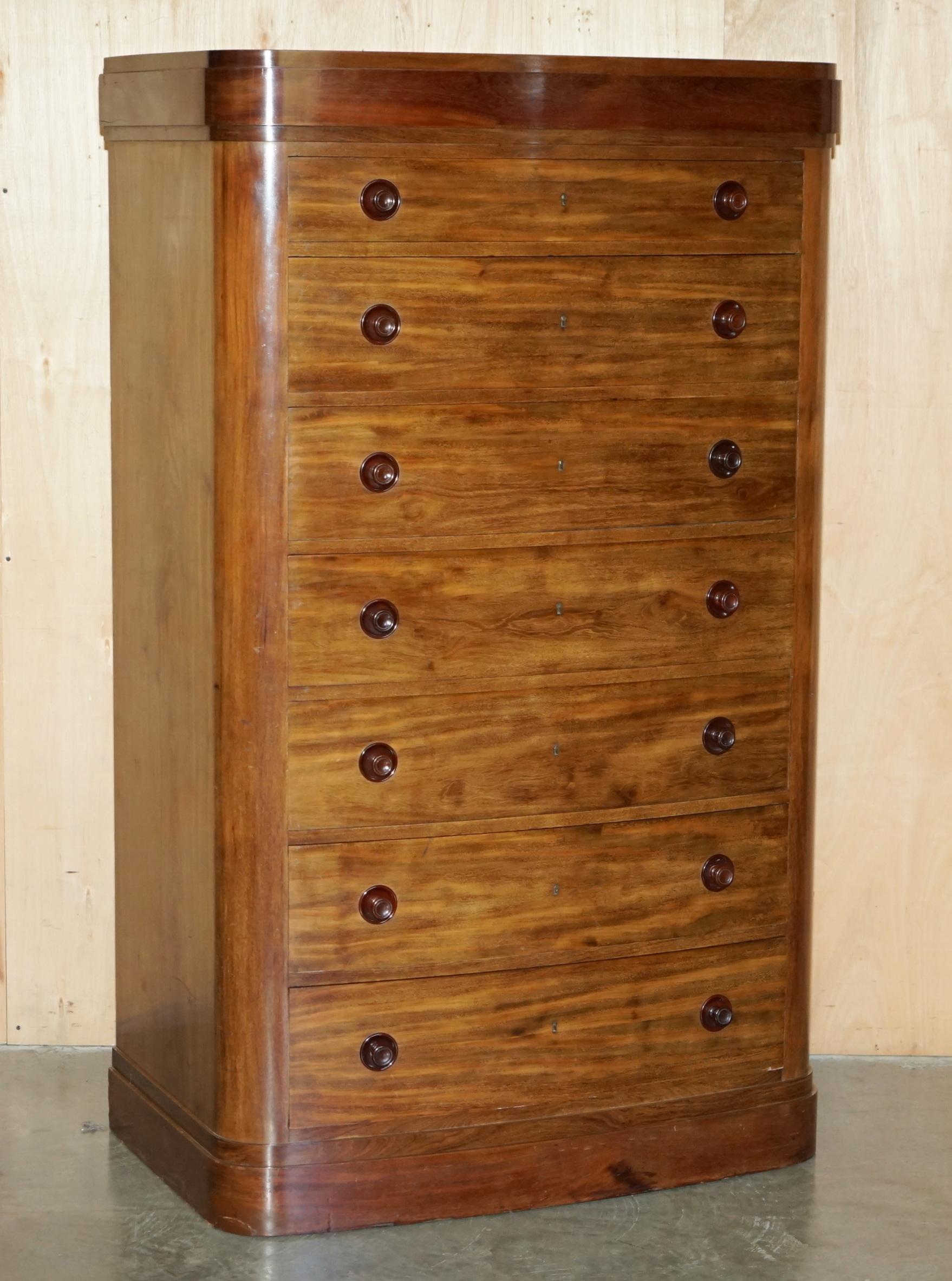 Pair of tall walnut chests of drawers with curved fronts in country style.