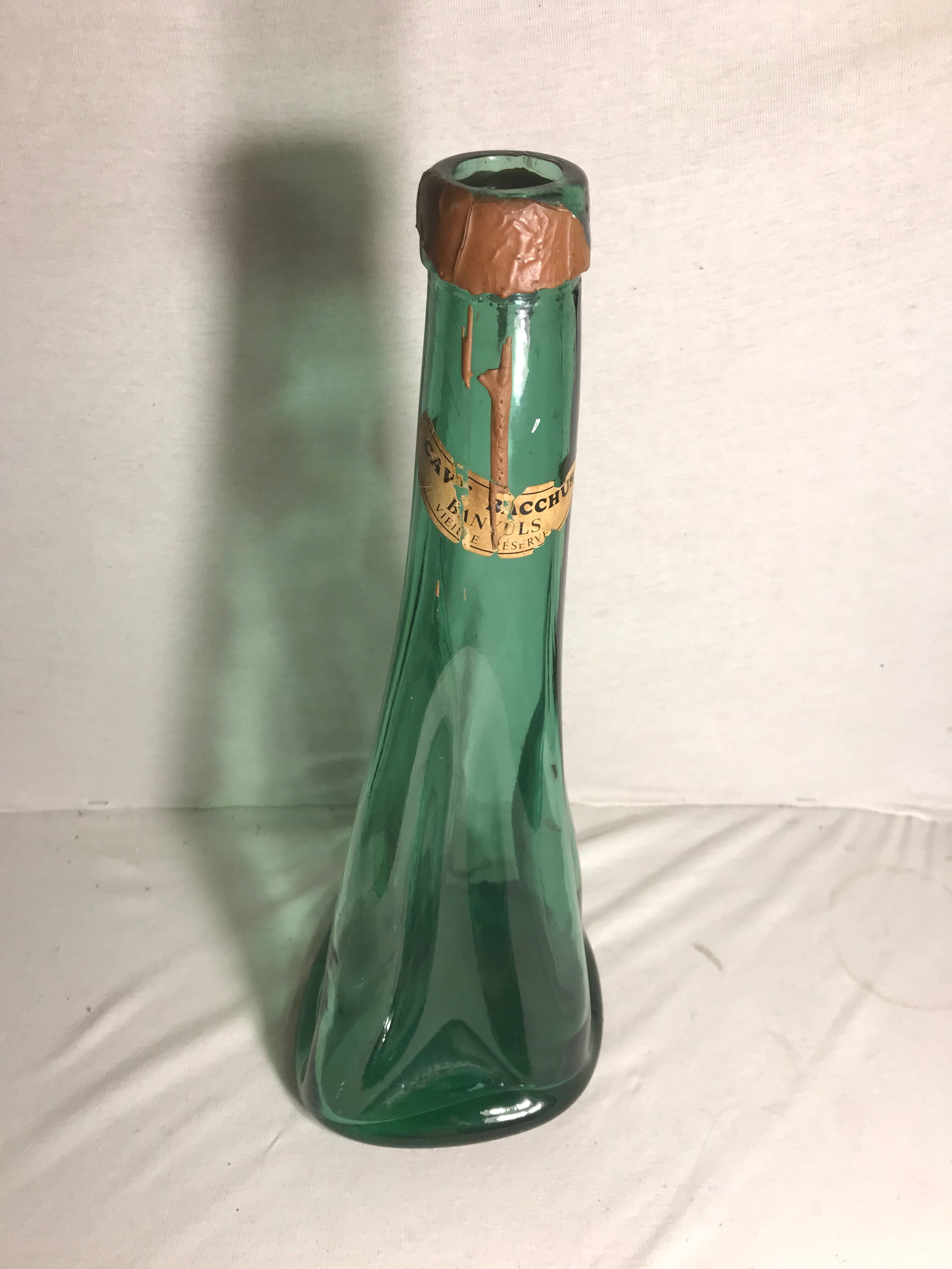 Old green molded glass bottle with rounded shape