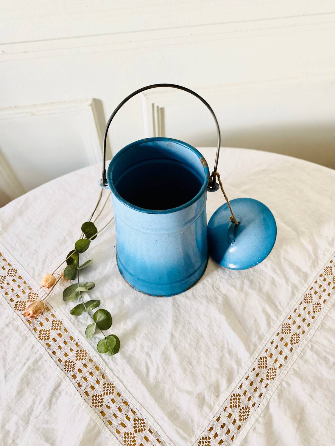 Old vintage milk jug in degraded blue enameled sheet metal