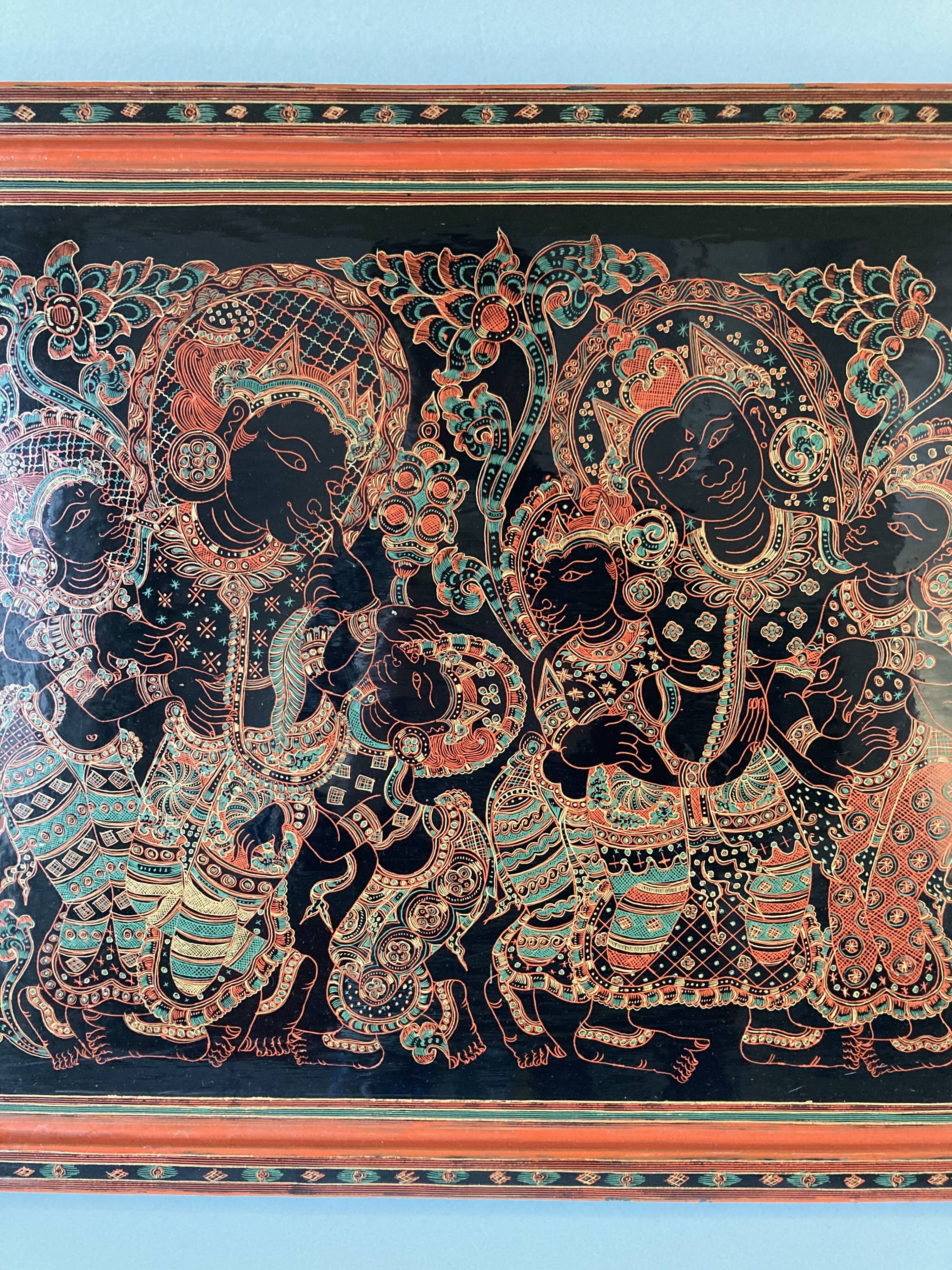 Grand plateau rectangulaire en bois laqué et gravé à décor de personnages. Birmanie, vers 1970.