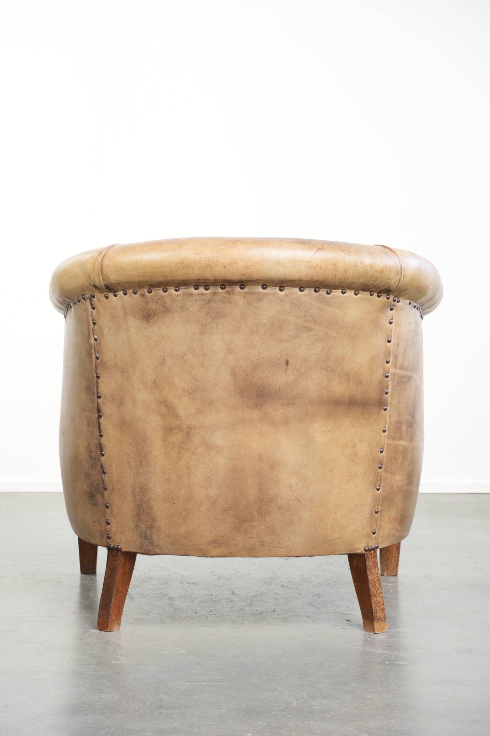Vintage cowhide club armchair in English style in a light colour scheme