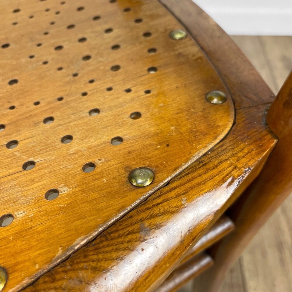 Pair of curved wood bistro chairs and studded and perforated seat