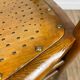 Pair of curved wood bistro chairs and studded and perforated seat