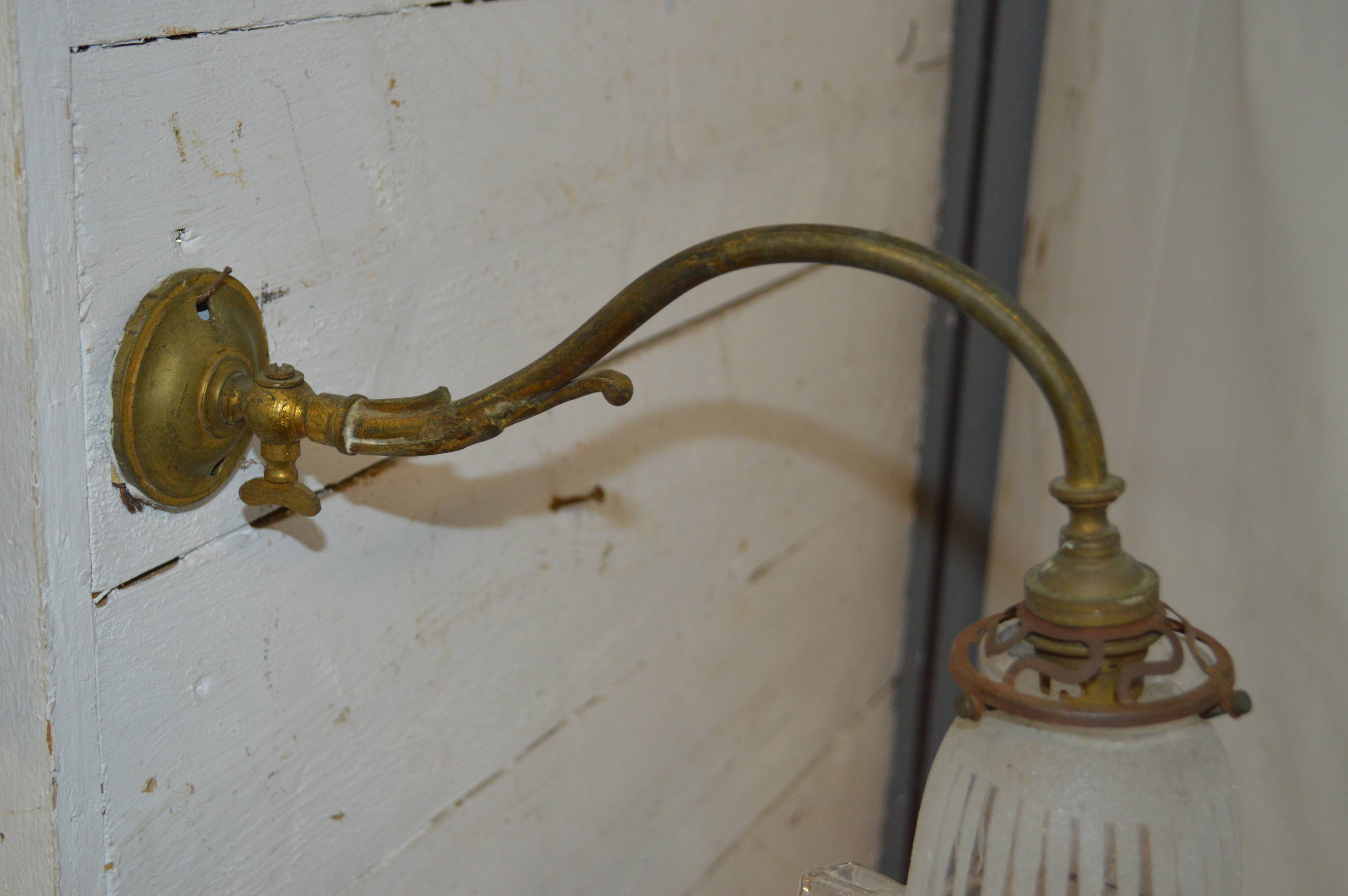 Brass wall sconce with a glass tulip