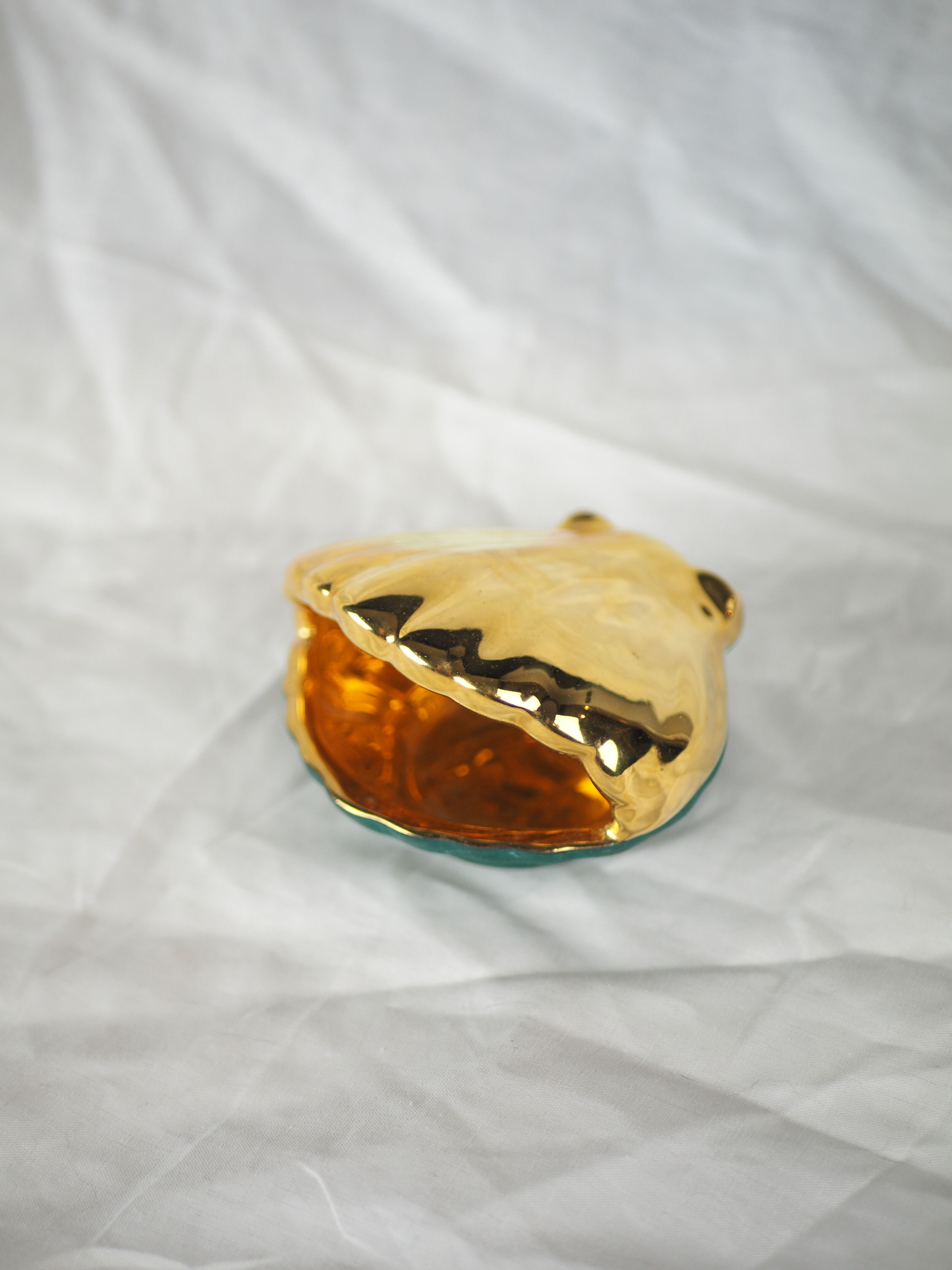 Porcelain pocket tray in the shape of a golden scallop shell with duck green background from the 50s/60s