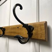 Antique wooden coat rack with metal hooks