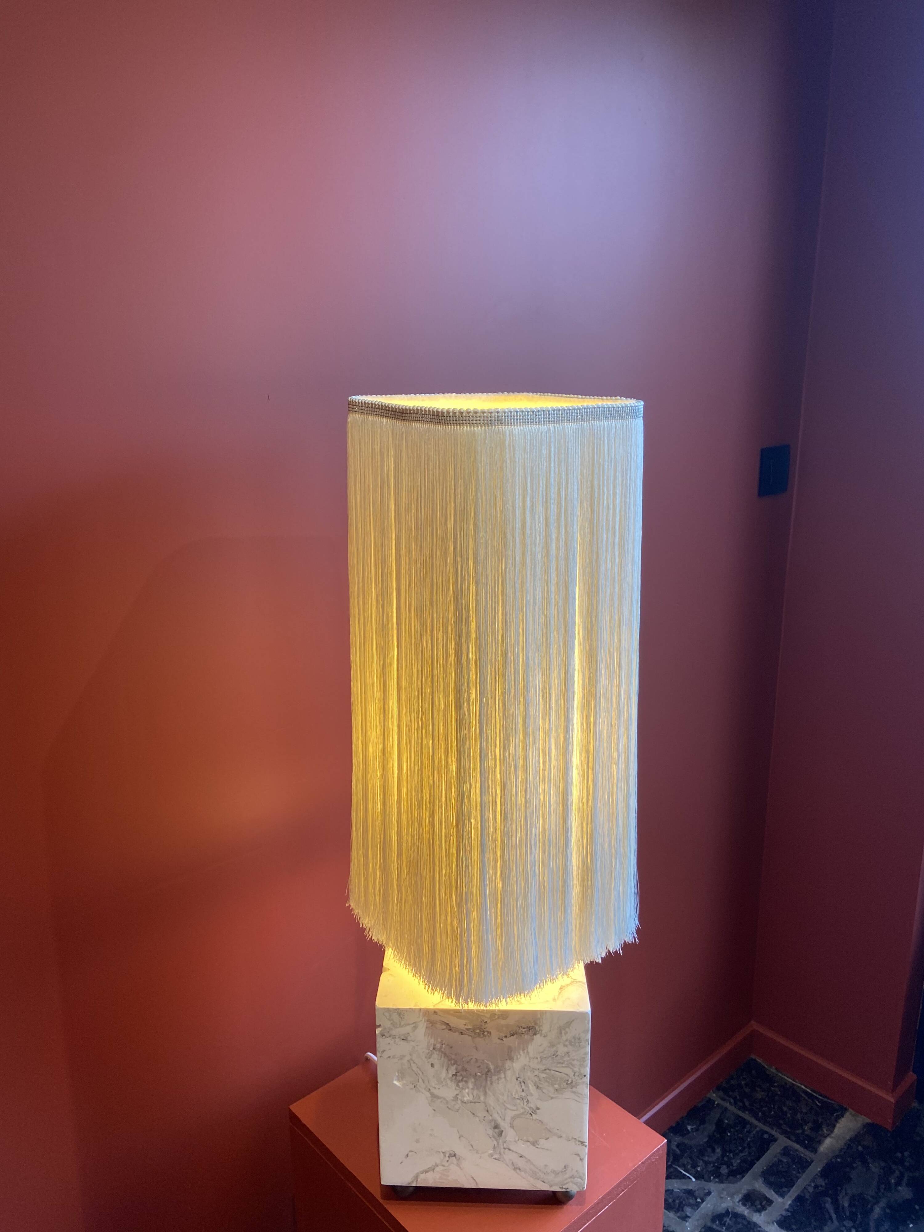 Beige marble stucco base, Houles white ecru fringed lampshade.