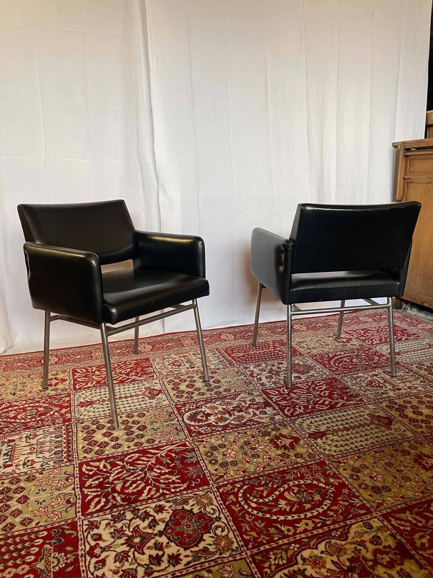 Pair of vintage armchairs in black faux leather and chrome metal.