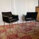 Pair of vintage armchairs in black faux leather and chrome metal.