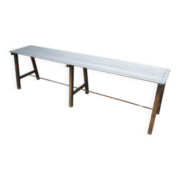 Long metal bench with tubular seat