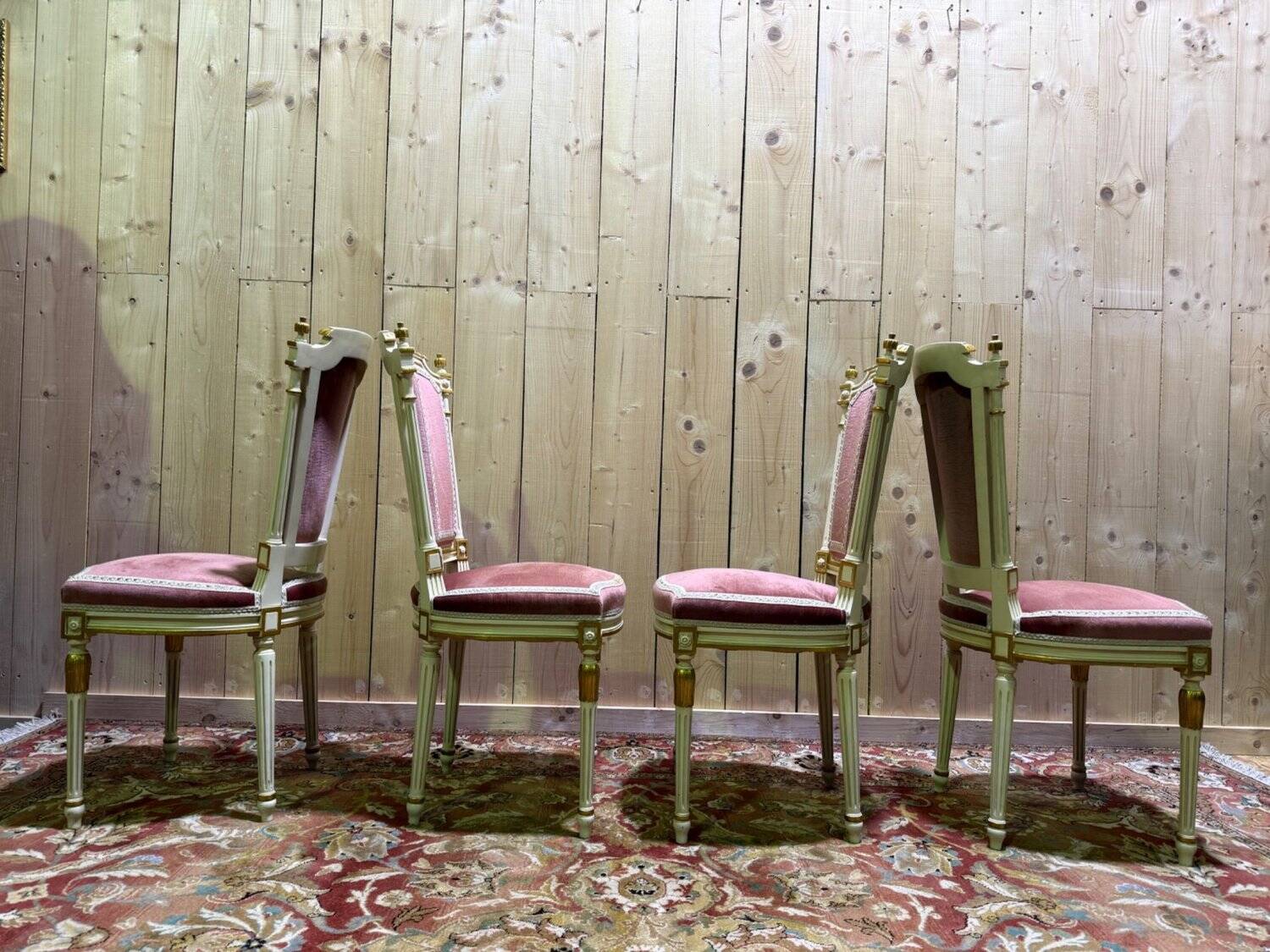 Louis XVI dining room table set with painted wood, gold accents, and pink velvet.