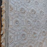 White bed throw with relief embroidery and floral patterns