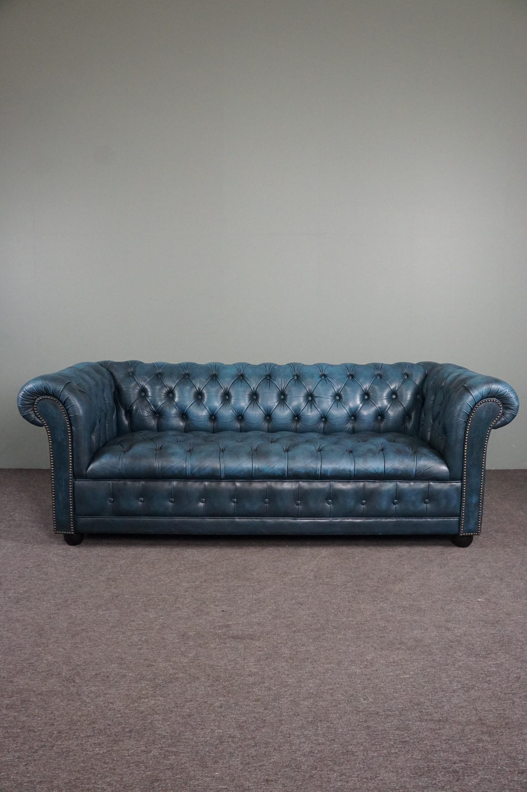 Chesterfield sofa buttoned in blue cowhide, 2.5 seats