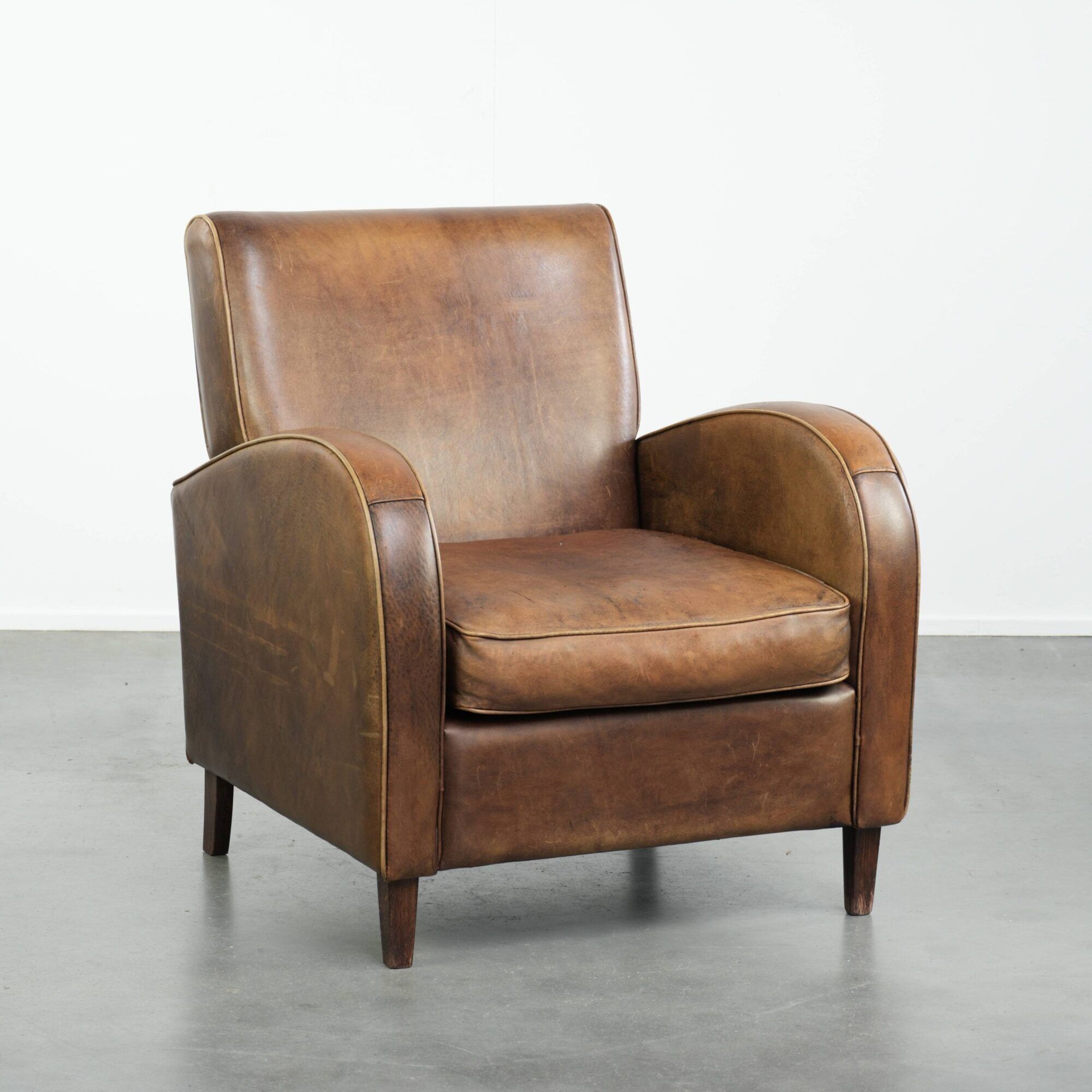 Sheepskin armchair in a light cognac colour with matching piping