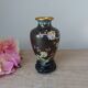 Small black cloisonné vase decorated with yellow and pink cherry blossoms, vase on wooden base