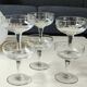 Set of 6 Baccarat-style champagne glasses. Stylized grape cluster decoration.