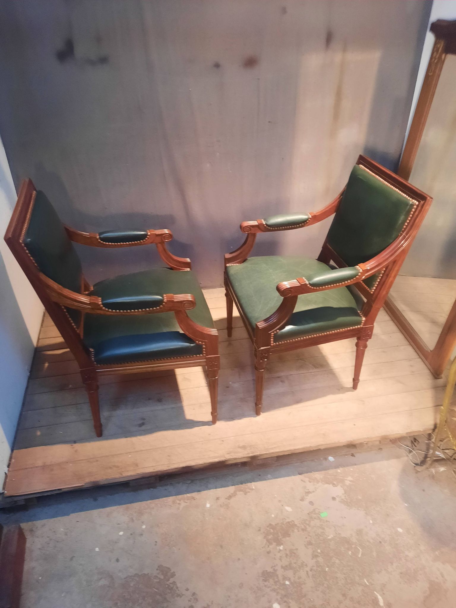 Pair of Louis XVI style armchairs upholstered in green leather.