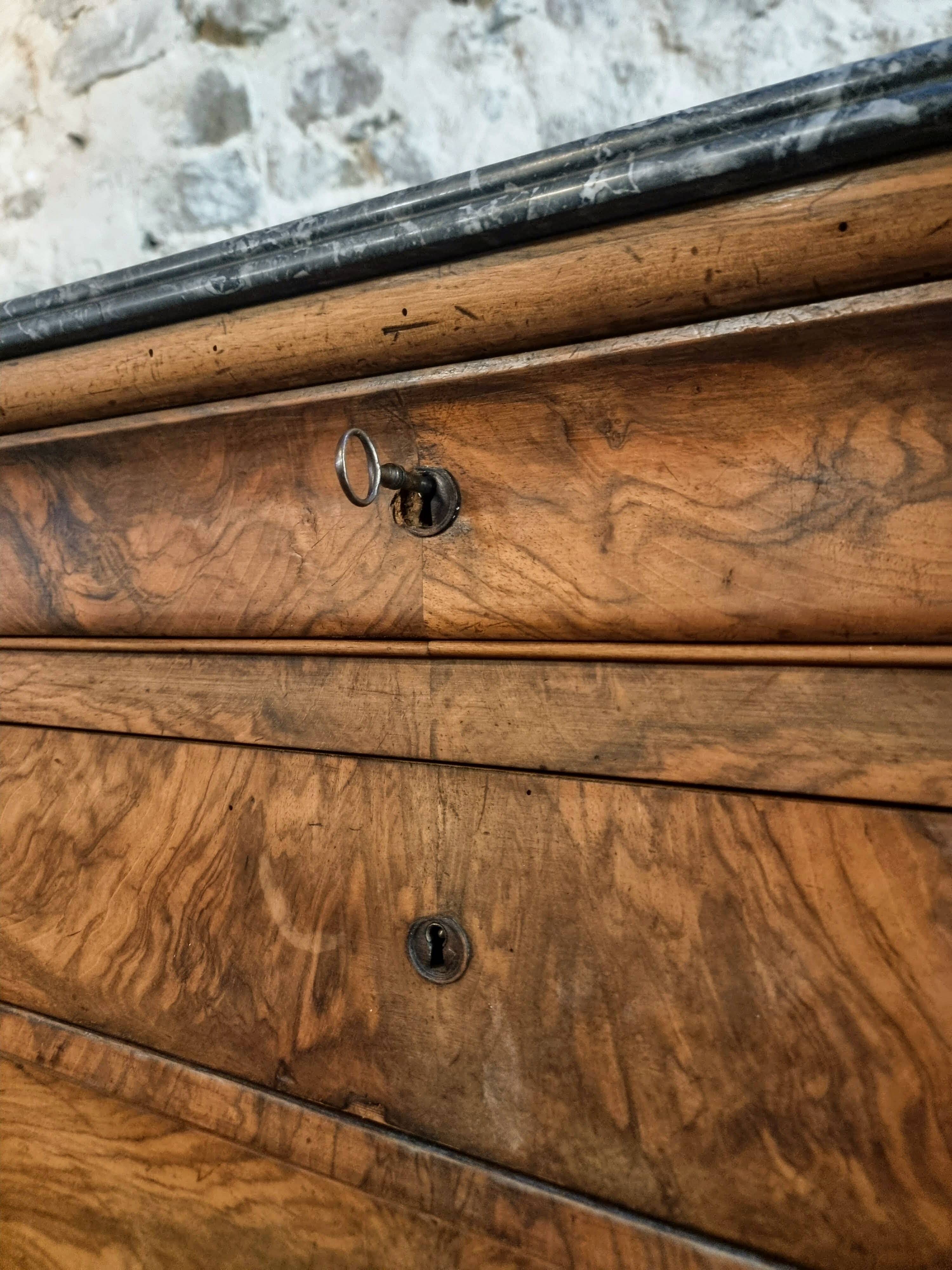 French antique walnut commode with a dark grey marble top, circa 1830–1860.