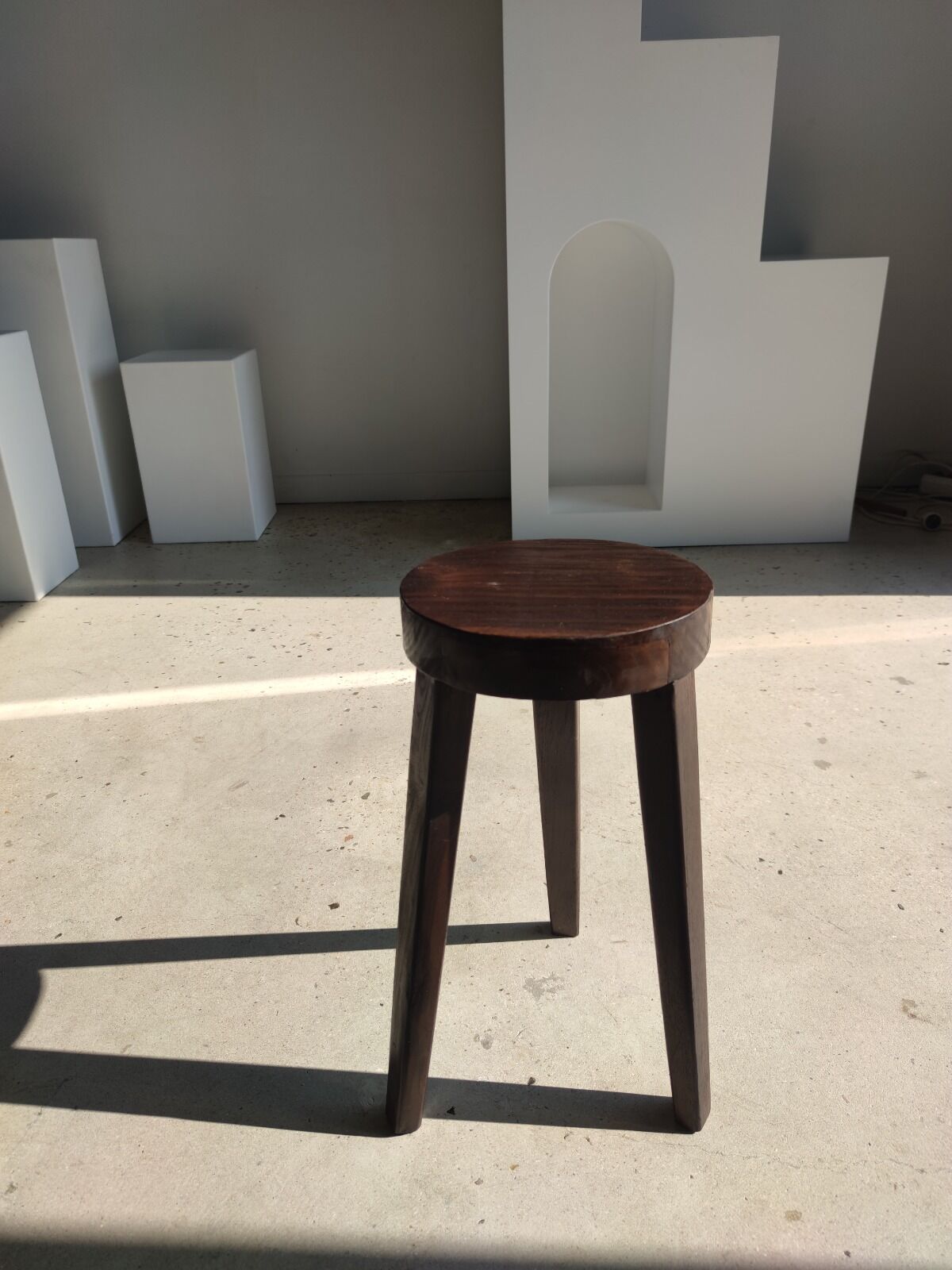 Small high tripod stool in brown solid wood