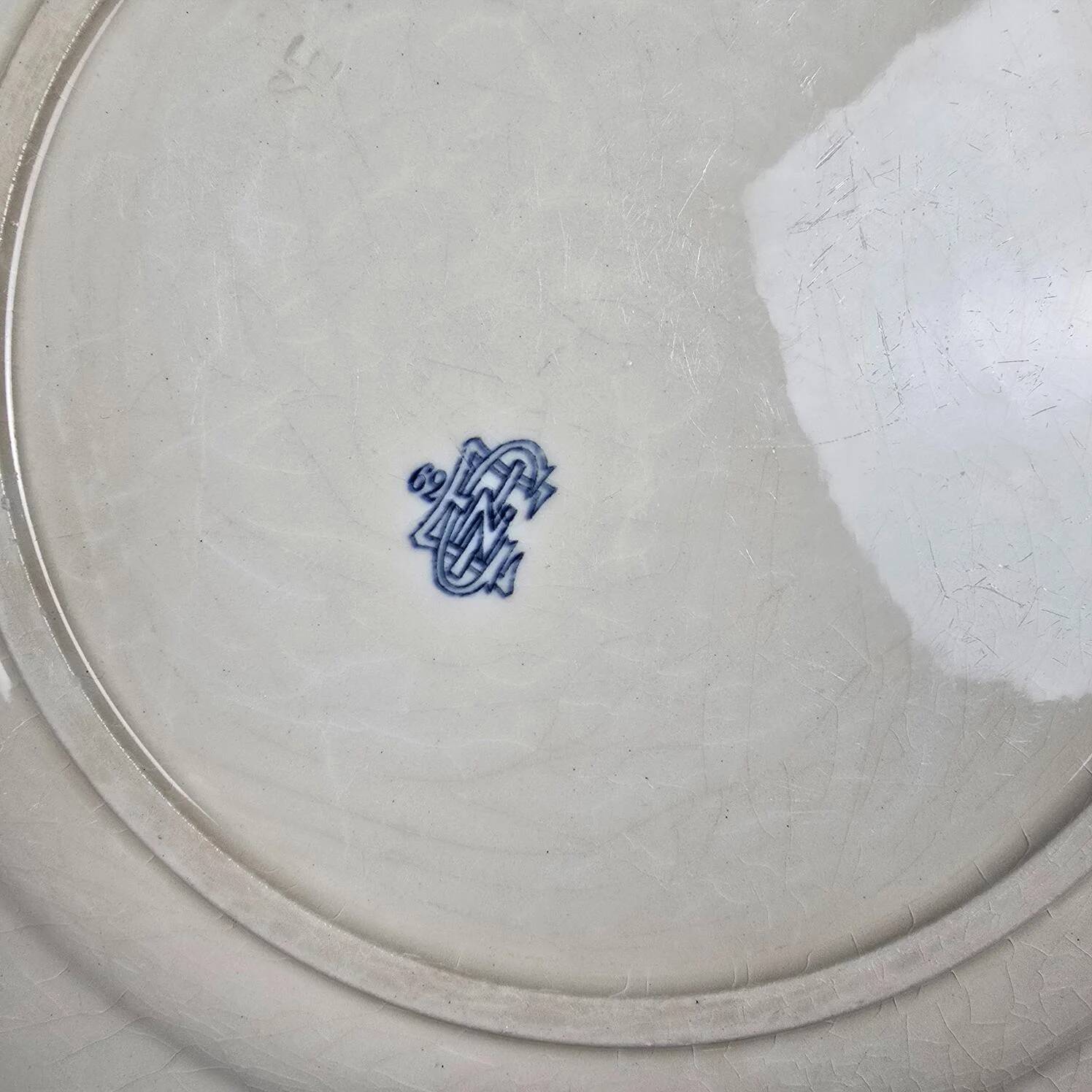 Old Gien plate with carved edges featuring doves and blue flowers, circa 1920-1930.