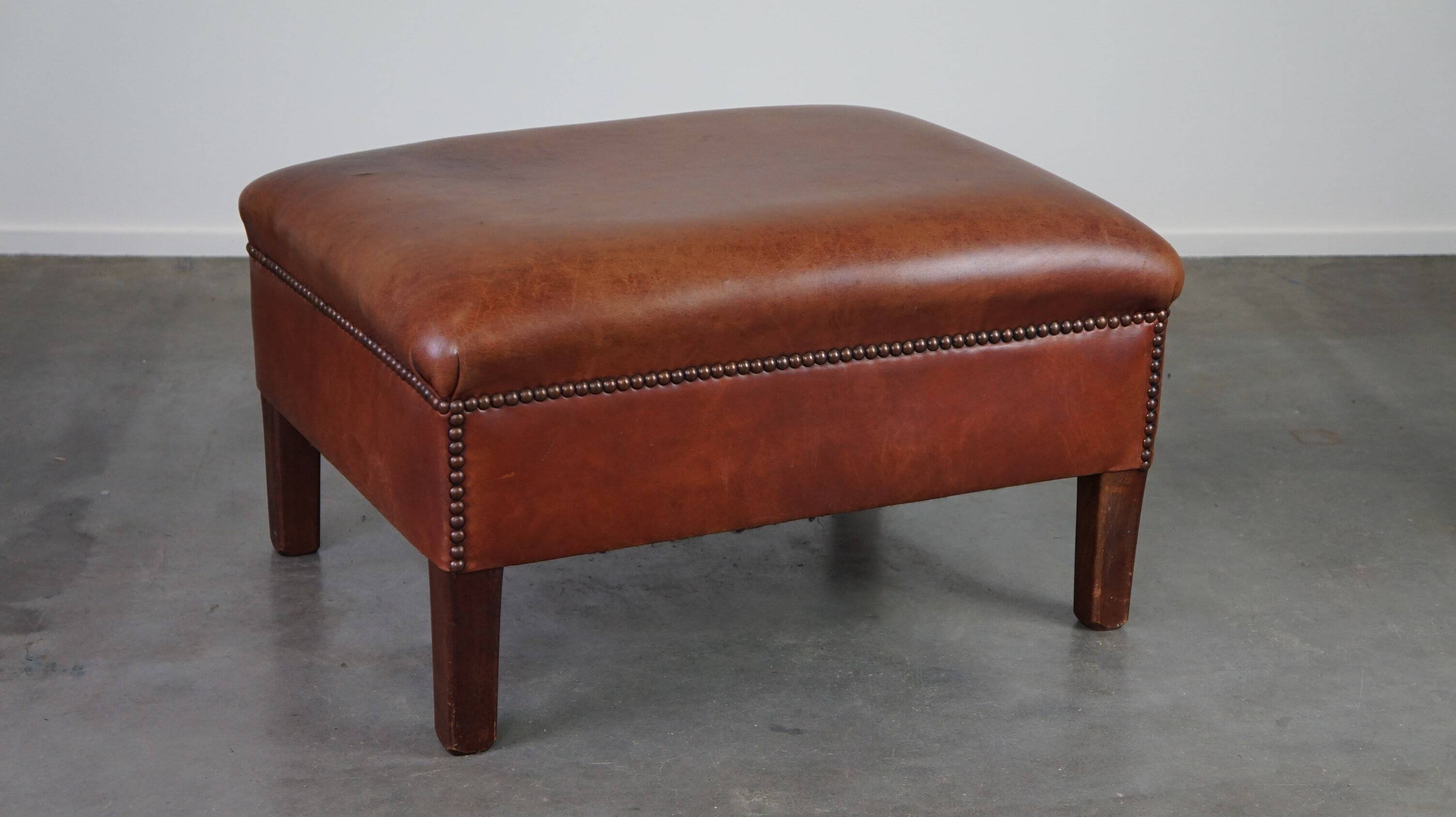 Leather ottoman in classic English style finished with decorative nails