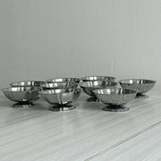 Set of 9 low bowls in shiny stainless steel.