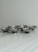 Set of 9 low bowls in shiny stainless steel.