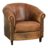Fauteuil club en peau de mouton vintage d'une belle couleur cognac avec un aspect robuste.