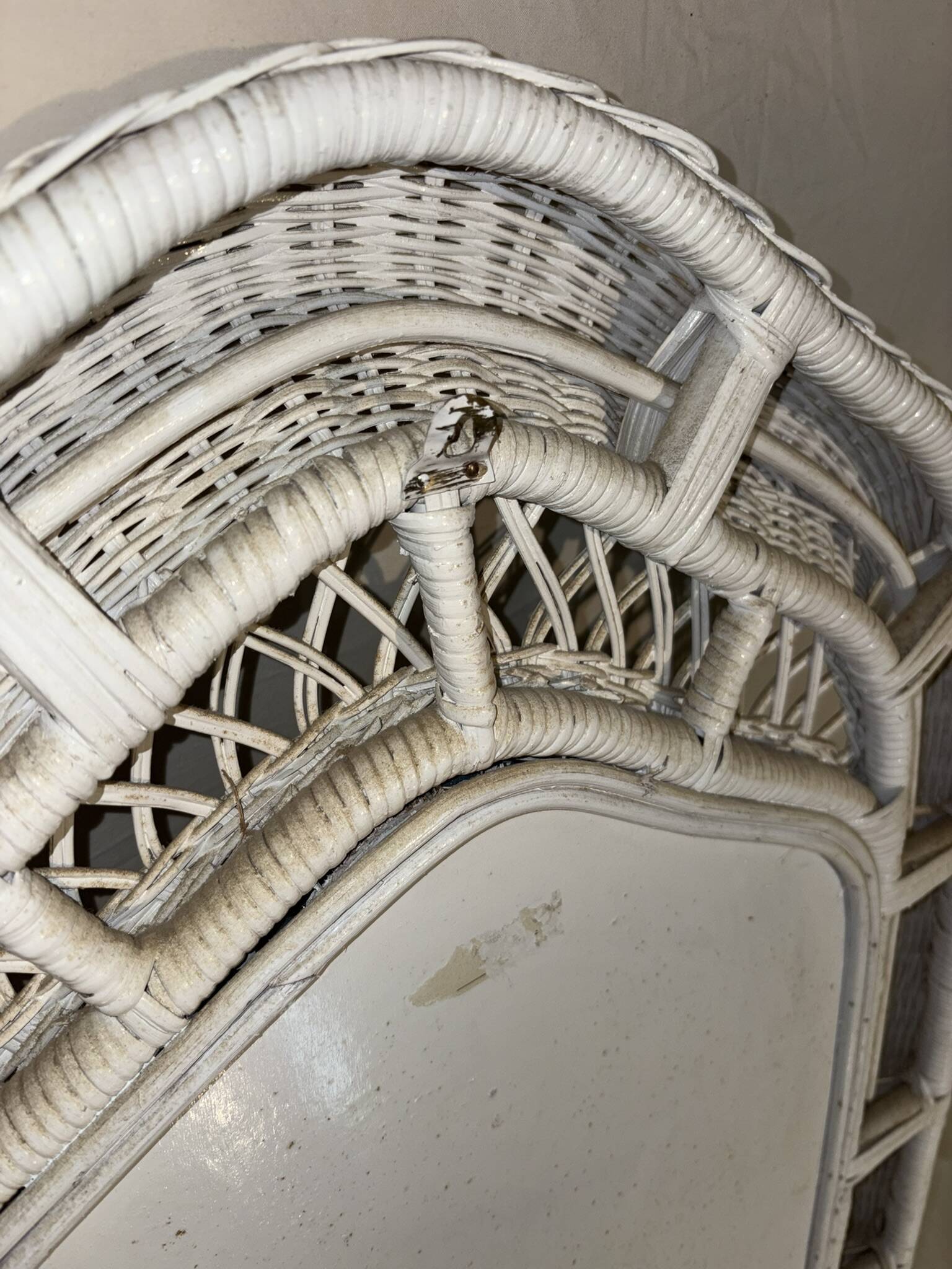 Vintage white rattan mirror with a gothic frame.