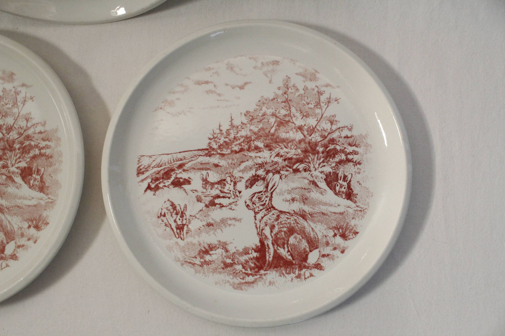 Set of 3 mismatched flat plates - red/burgundy decorations - deer and hare