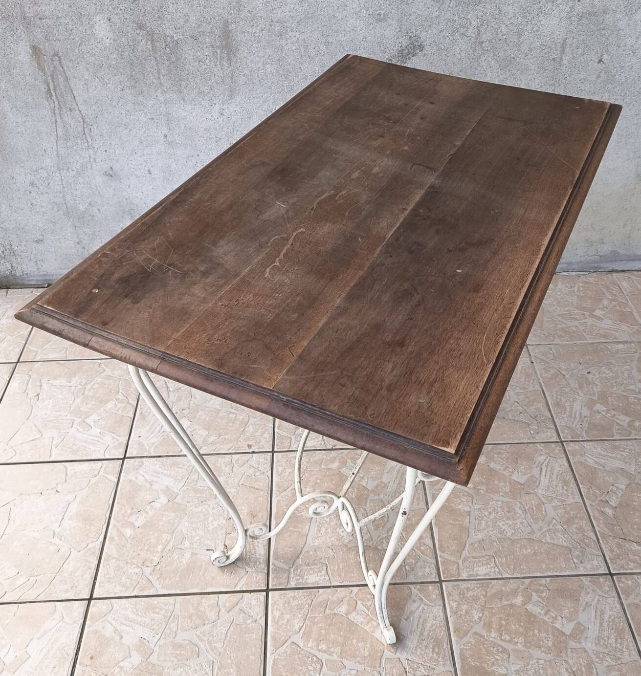 Wrought iron table with a walnut top.