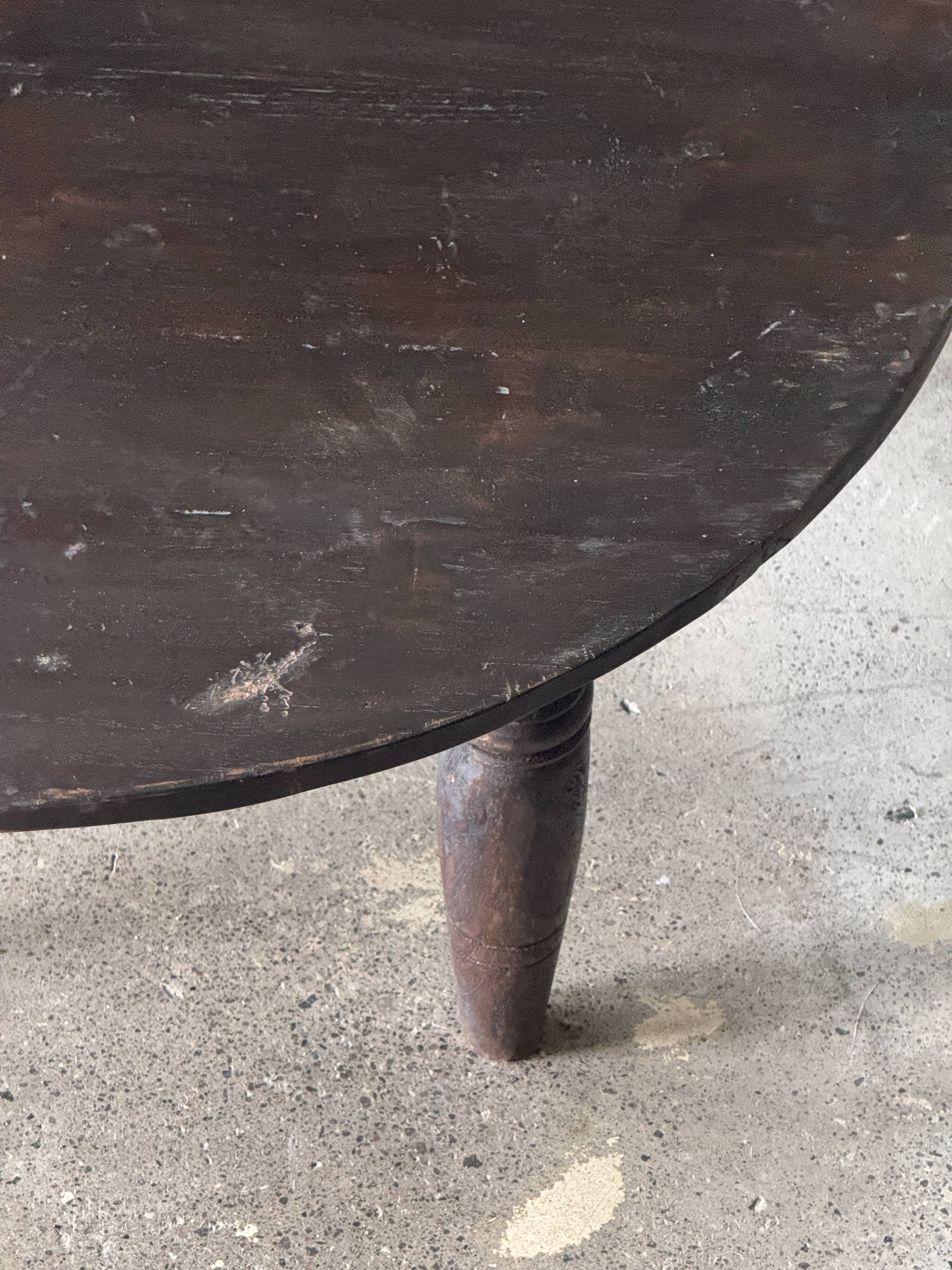 Antique round coffee table in Indonesian teak with turned legs.