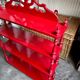 Wall shelf with 4 red lacquered wooden shelves.