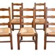 Set of 6 wooden chairs with straw seats and high backs.
