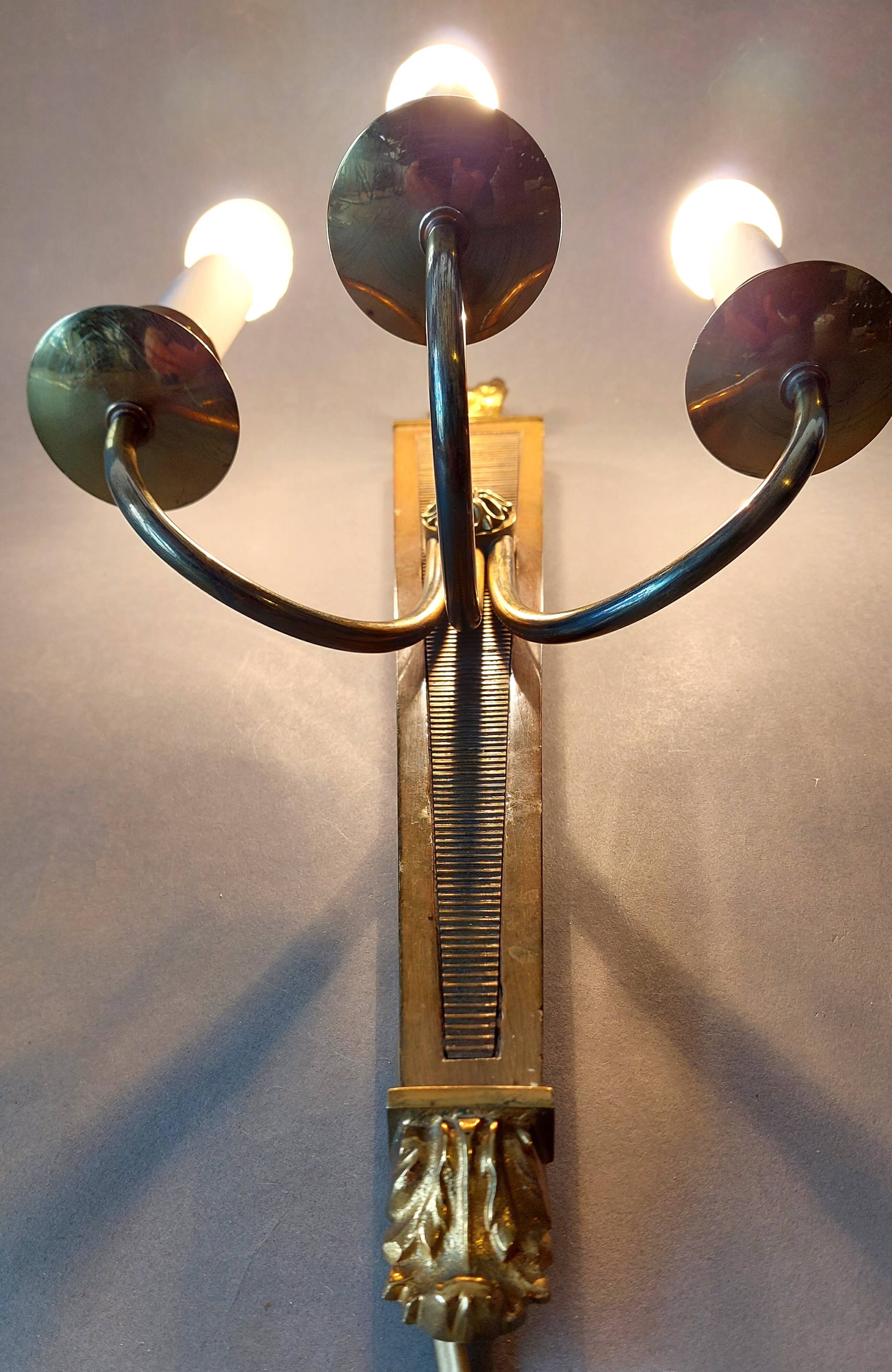 Wall lamp in the shape of a 1940 quiver with three arms, gilded brass and solid mahogany.