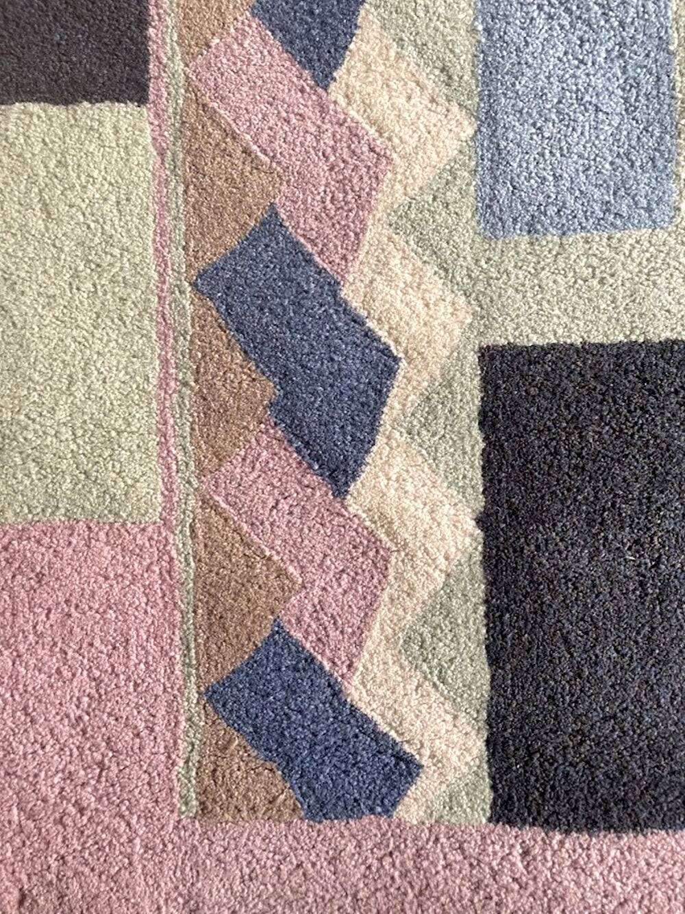 Hand-knotted wool rug by Tisca with a geometric pattern, signed "ILES", France, 1990s.