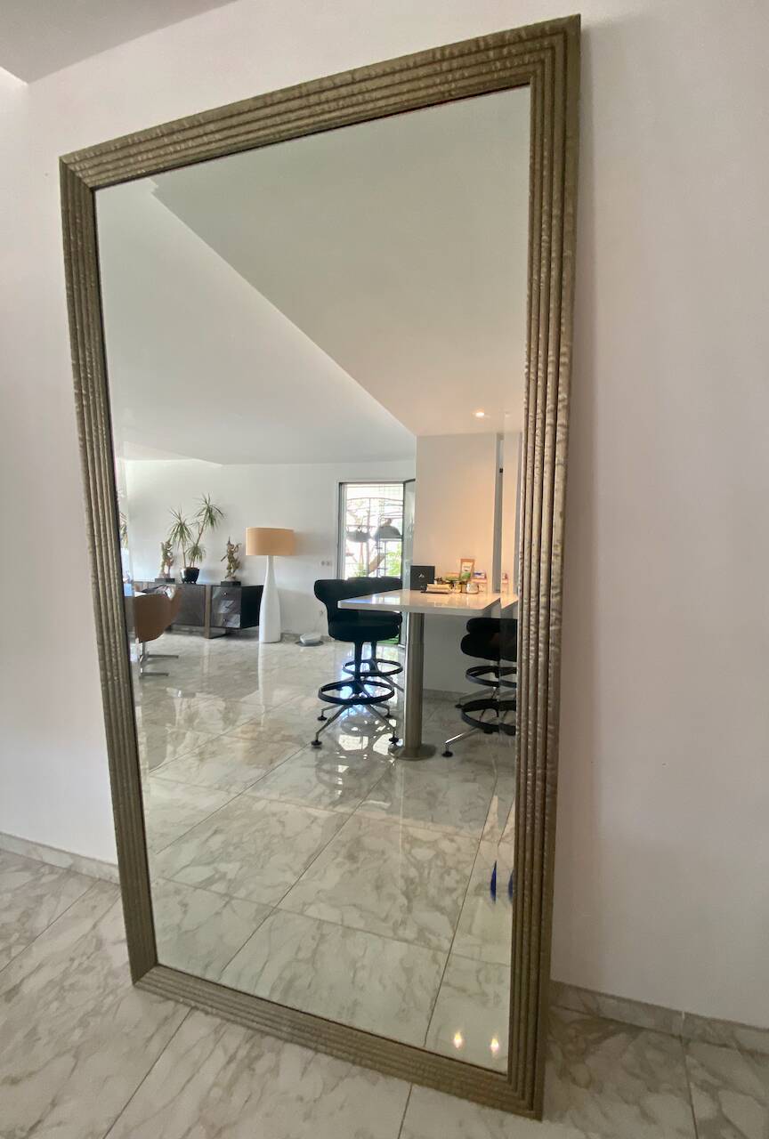 Textured embossed metal wall mirror with bevelled mirror.