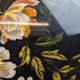 Large vintage 1960s platter with floral decoration on a black background and golden handles.