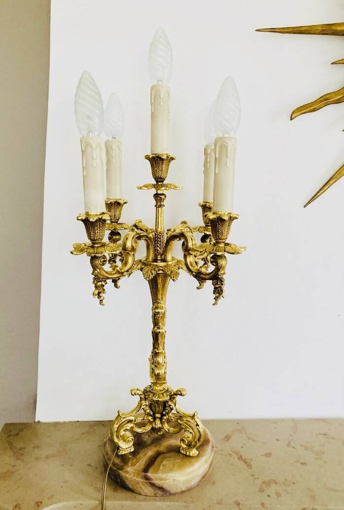 Massive gilded bronze chandeliers from the mid-20th century with marble bases.