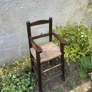 Vintage wooden children's high chair with straw.