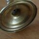 Brass candle holder with flowers and round shape.