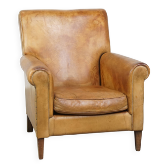 Stylish patinated vintage sheepskin armchair with a comfortable seat