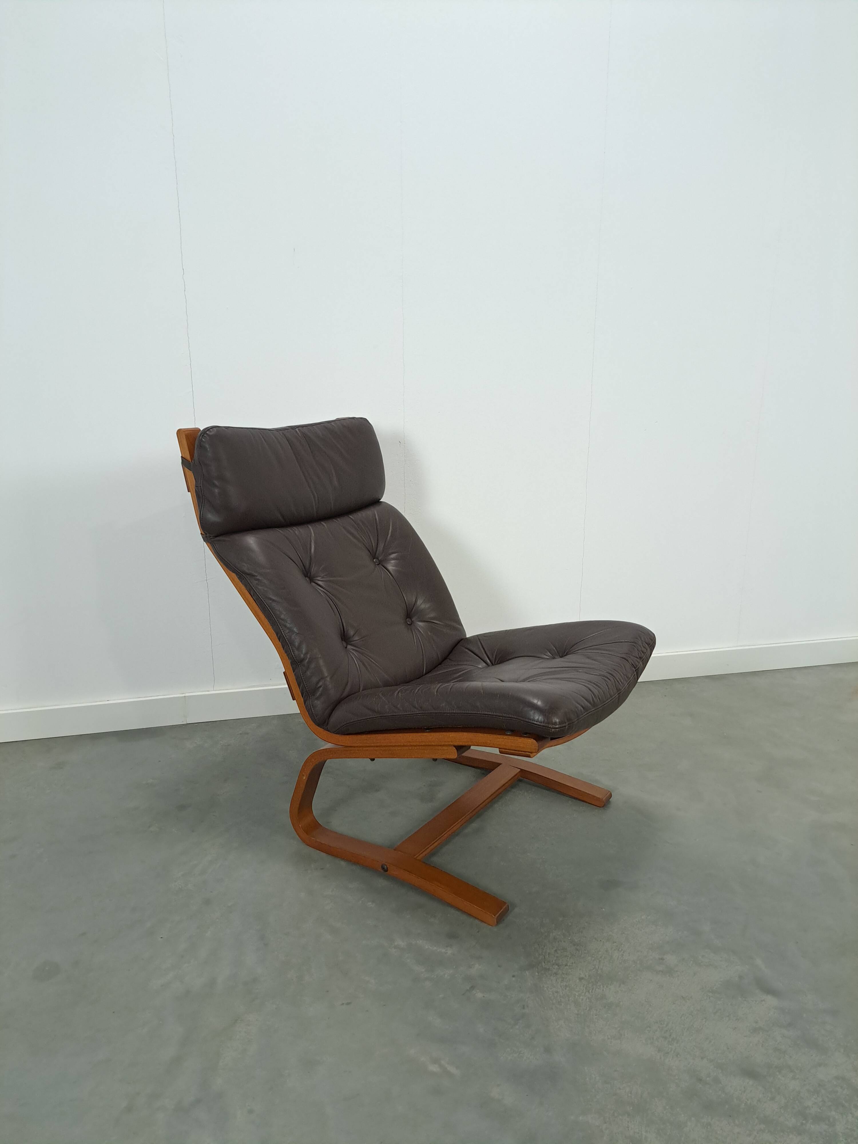 Bruin leren fauteuil met houten onderstel