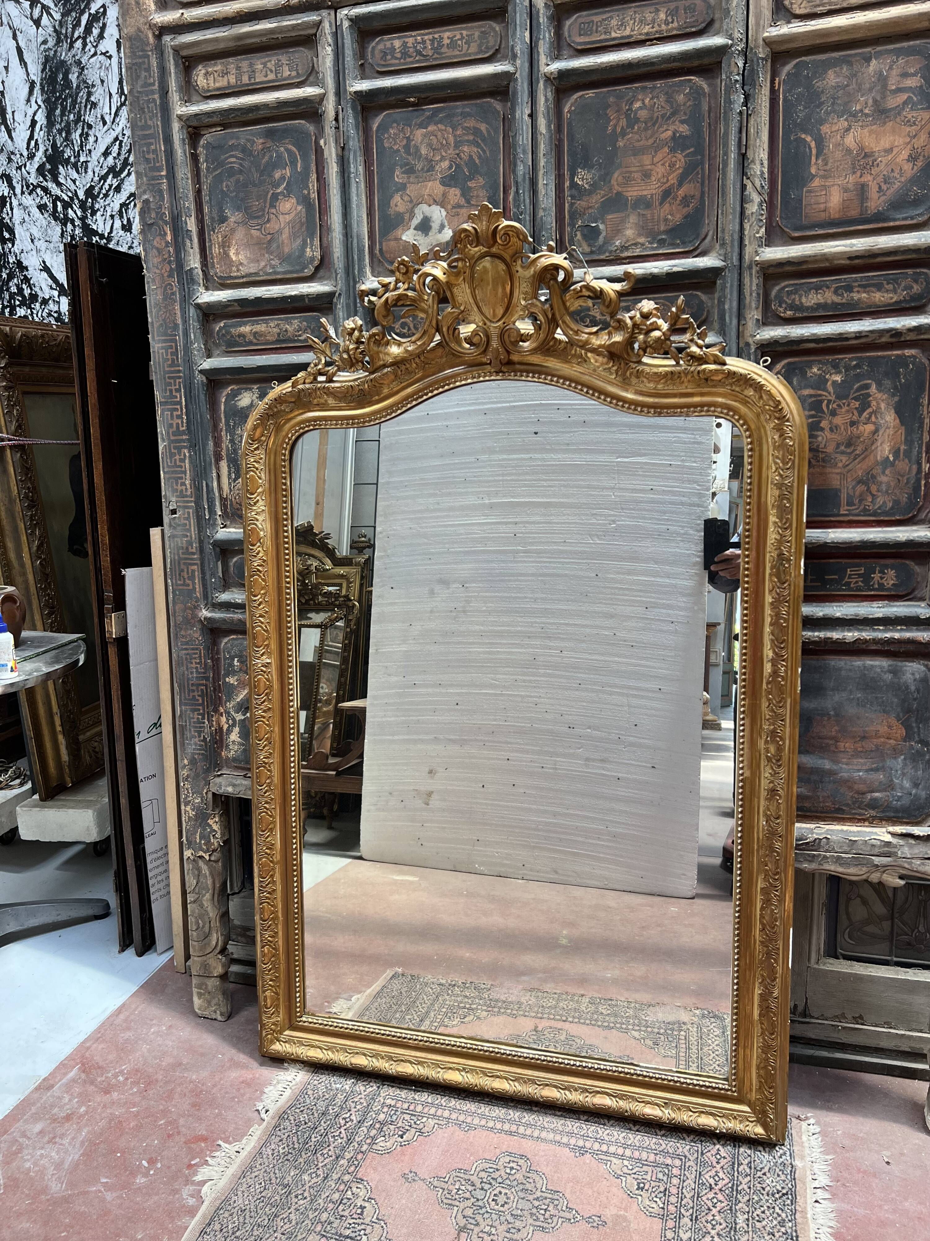 Louis XV style mirror in gilded wood and stucco, 20th century.