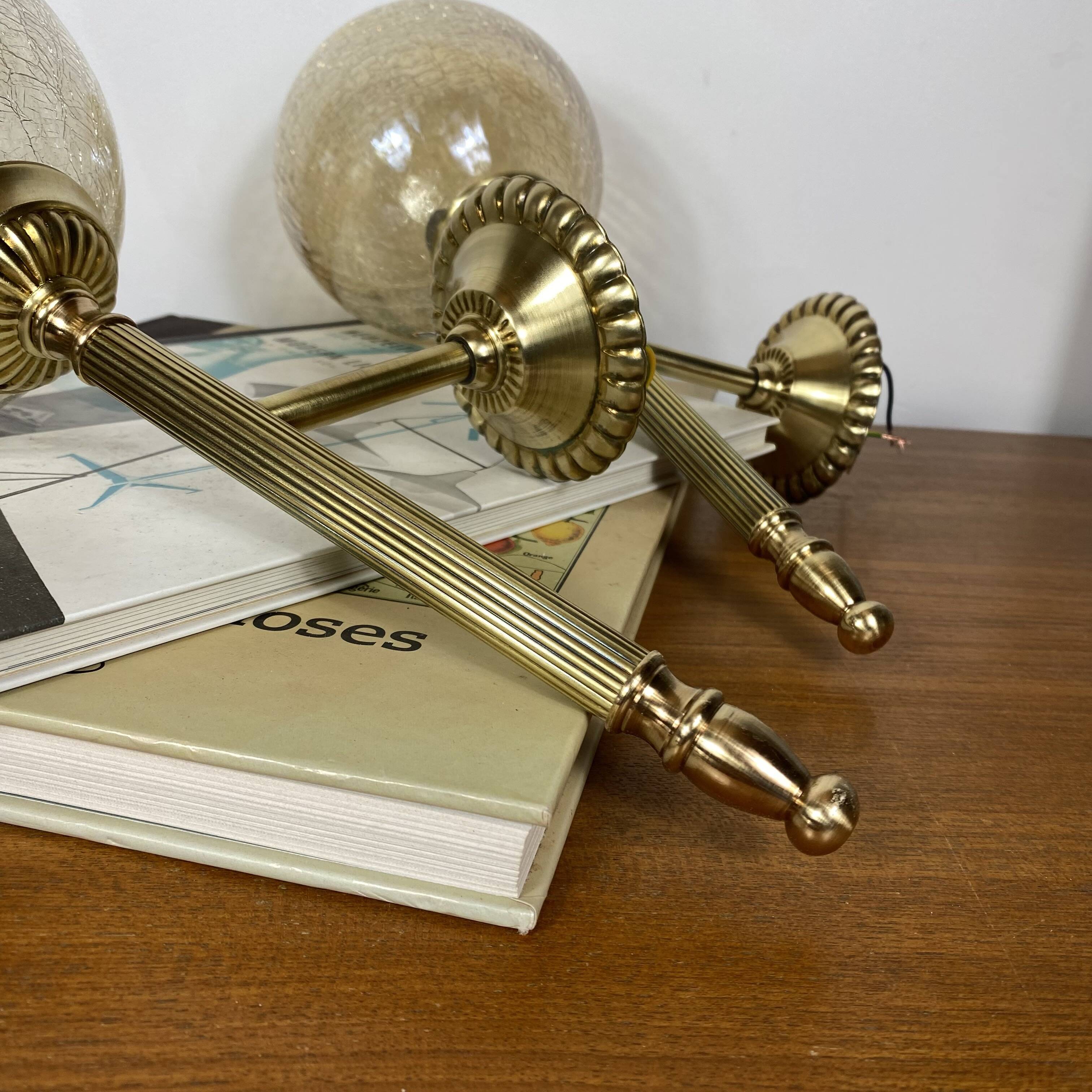 Pair of antique wall sconces torch style brass with glass globes in gold.
