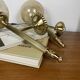 Pair of antique wall sconces torch style brass with glass globes in gold.