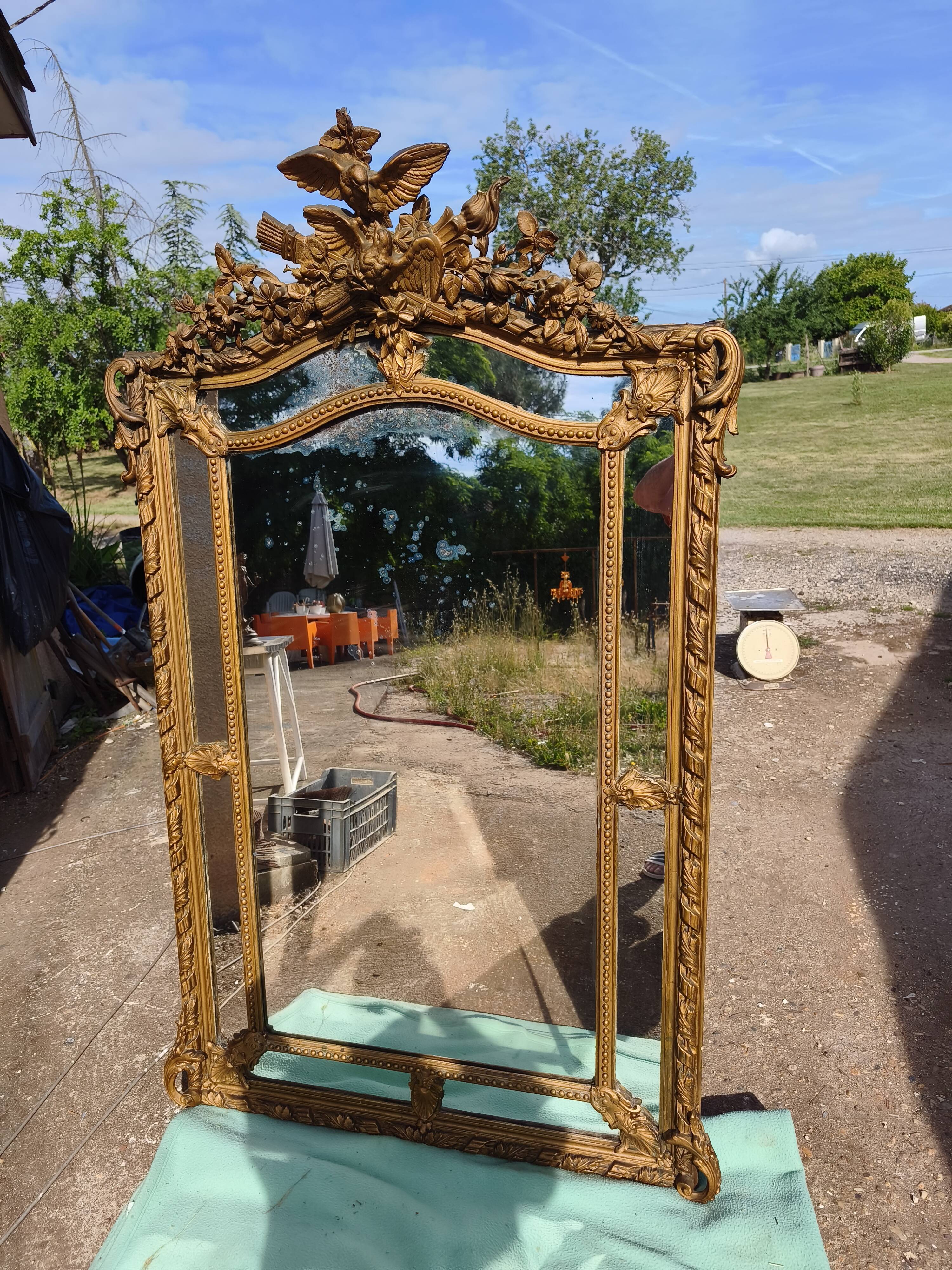 Large closed mirror, 19th century, wood and gilded stucco.